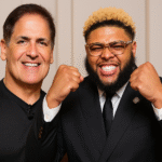 Two smiling men, one in suit, showing fists.
